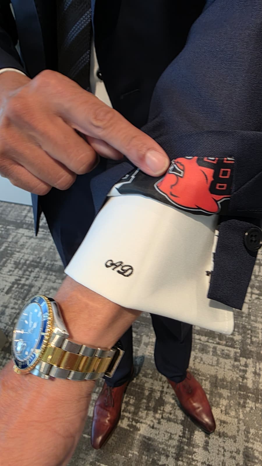 Monogrammed shirt cuff under a navy custom jacket