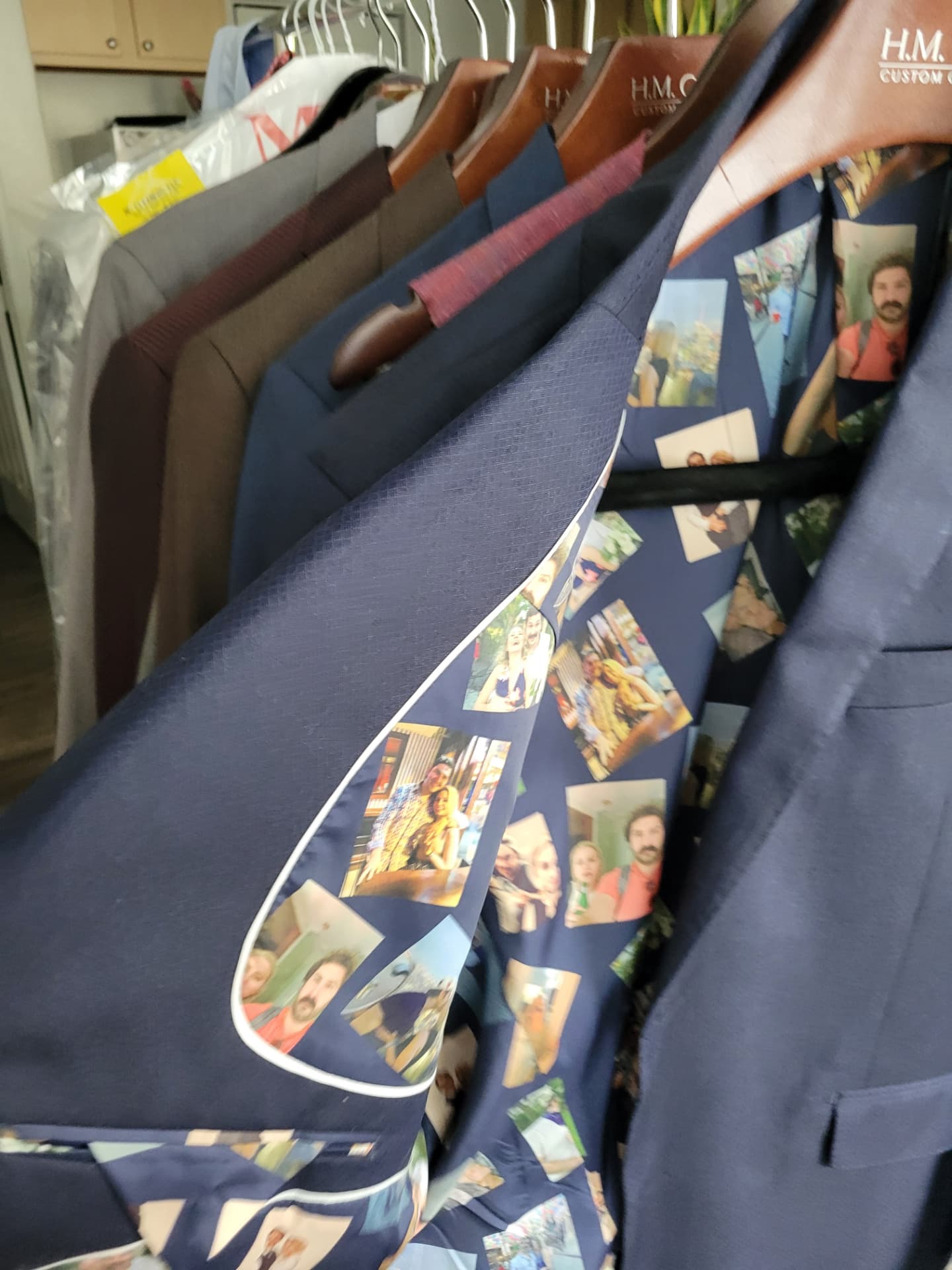 Rack of finished custom jackets on branded hangers, one opened to show a printed lining