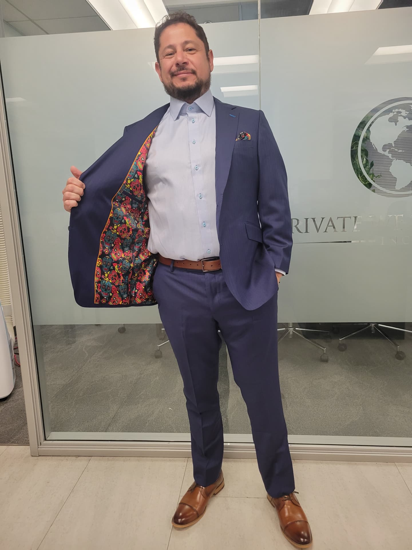 Navy suit jacket opened to reveal a bright sugar-skull patterned lining