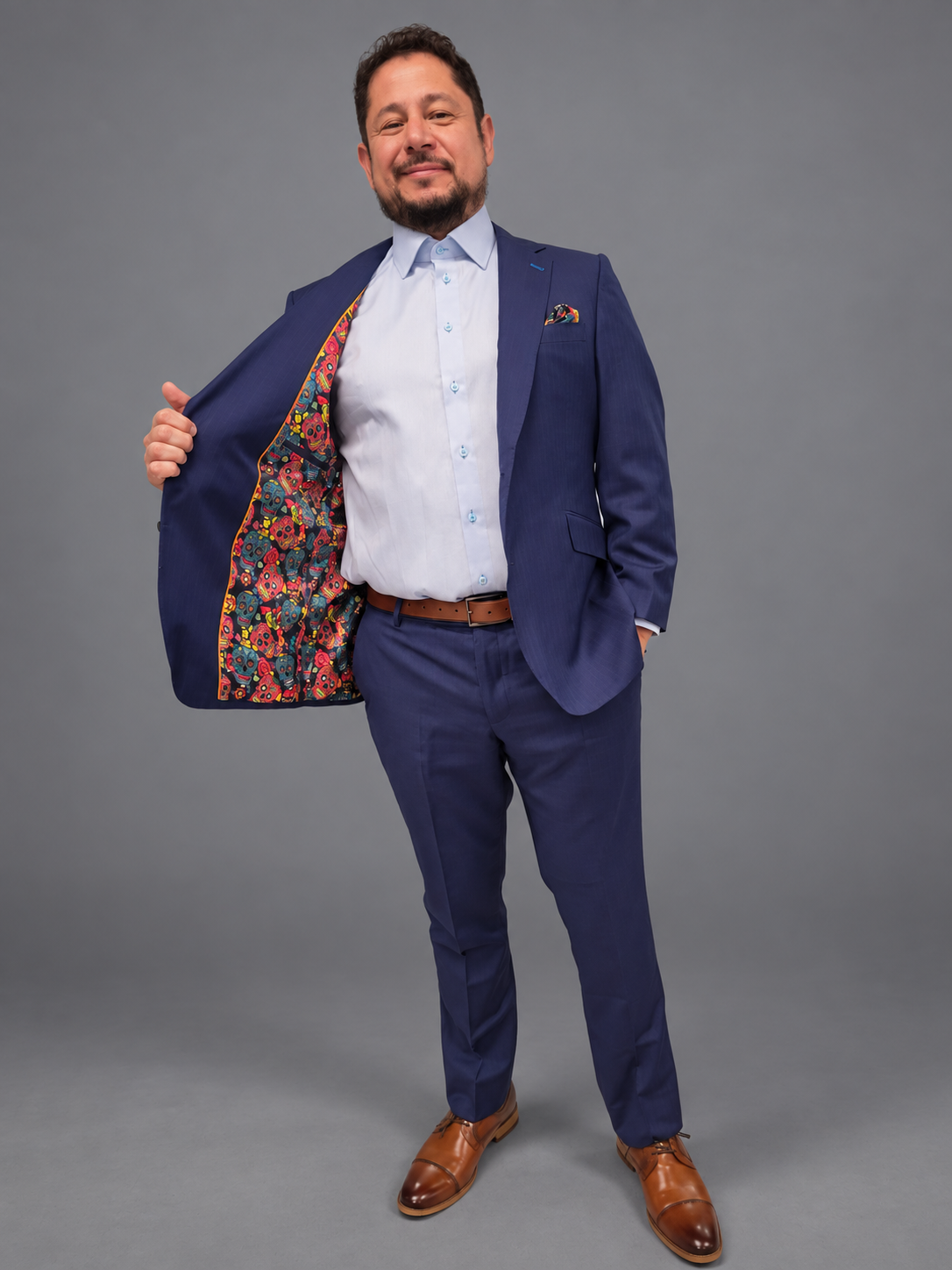 Navy suit jacket opened to reveal a bright sugar-skull patterned lining