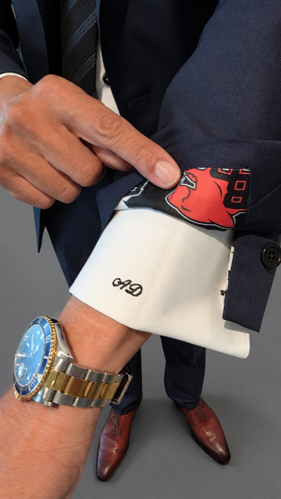 Monogrammed shirt cuff under a navy custom jacket
