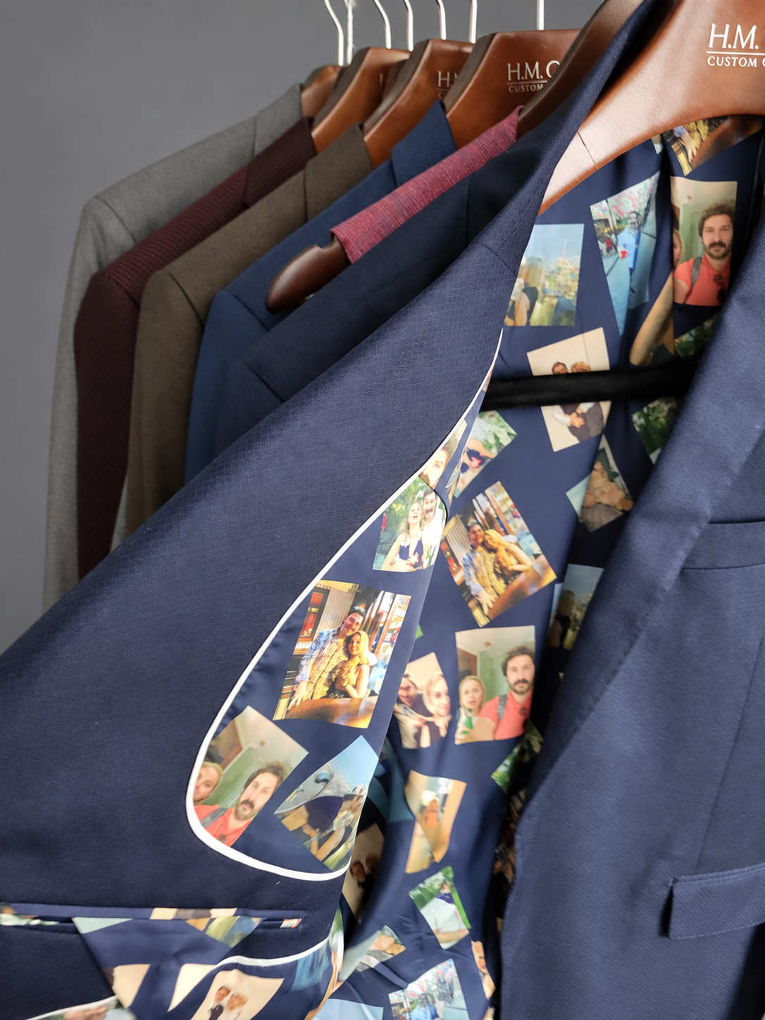 Rack of finished custom jackets on branded hangers, one opened to show a printed lining